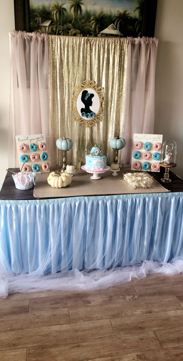 the dessert table is set up with blue and pink decorations