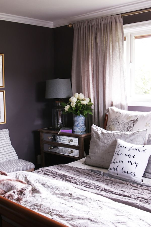 a bedroom with a bed, nightstand and window in the corner is shown on instagram