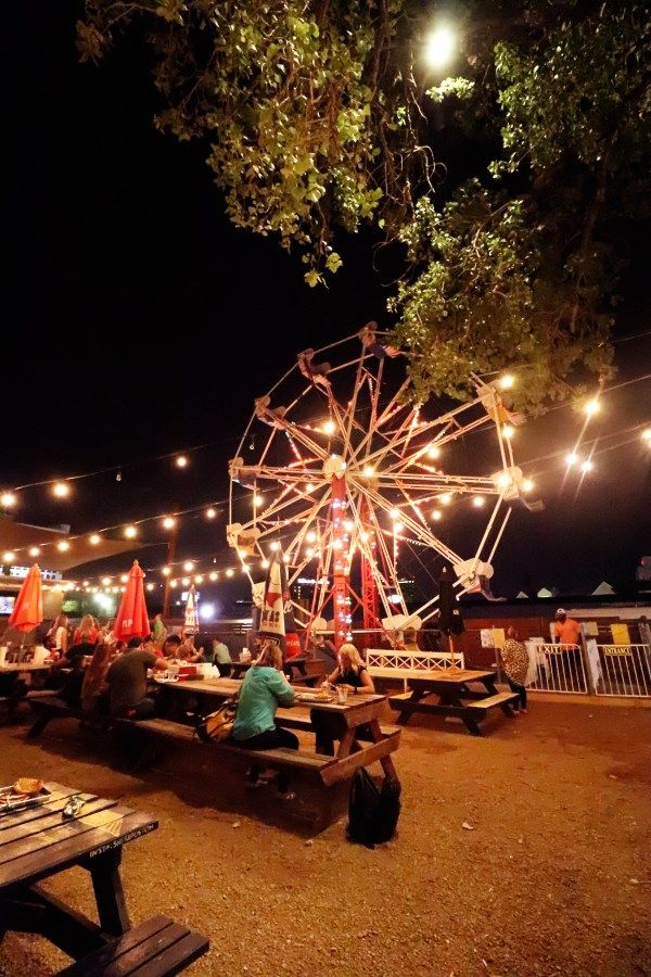 a ferris wheel in the middle of a park at night with text overlay reading 6 unique places to eat in dallas texas