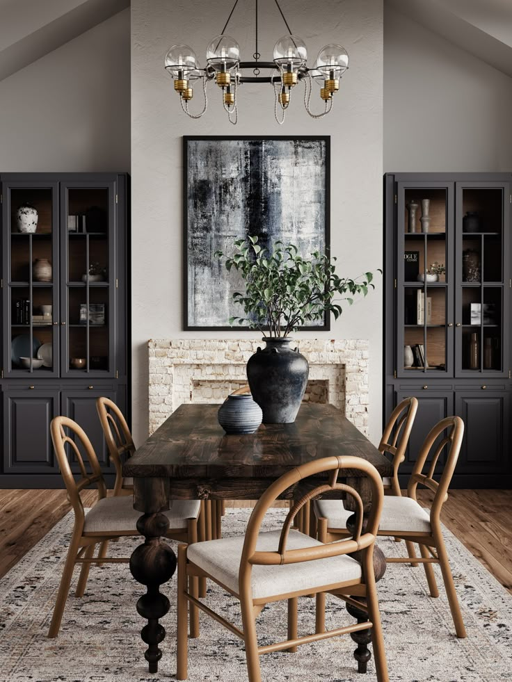 a dining room table with chairs and a potted plant on it in front of a fireplace