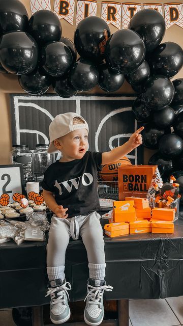 a baby sitting on top of a table in front of black and white balloons with the words instagram