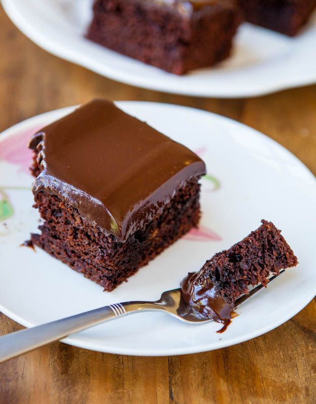 a piece of chocolate cake sitting on top of a white plate next to a fork