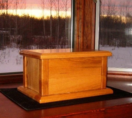 a wooden box sitting on top of a table next to a window with snow outside