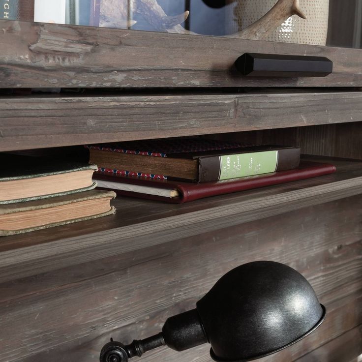 a book shelf with books and a lamp on it