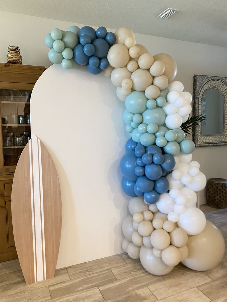 the balloon arch is decorated with blue, white and grey balloons in an elegant manner