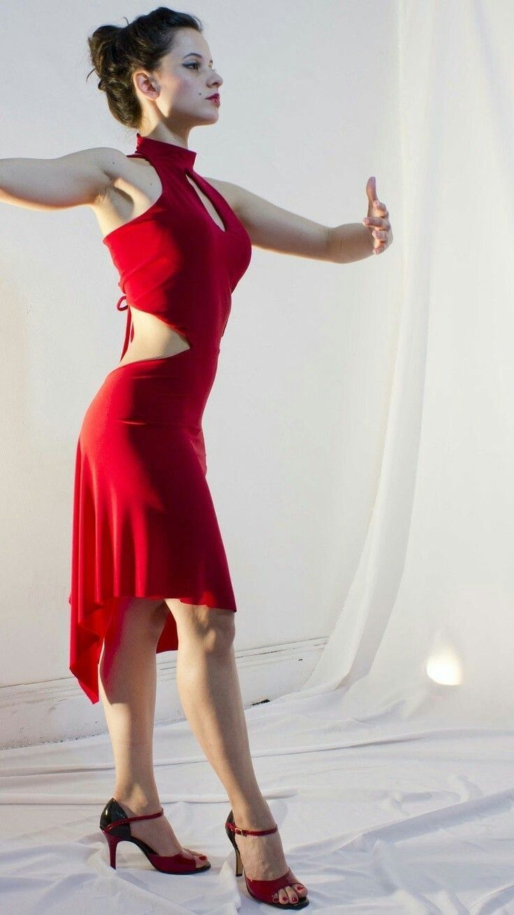 a woman in a red dress is posing for the camera with her arms spread out