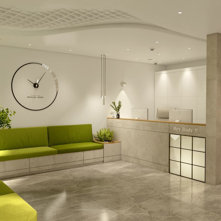 an office lobby with green couches and a clock on the wall