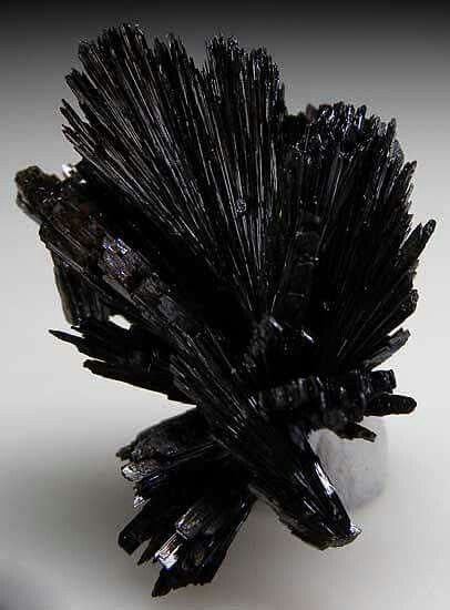 a cluster of black crystals sitting on top of a white table