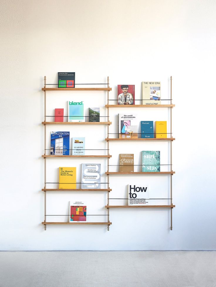 a book shelf with books on it against a white wall