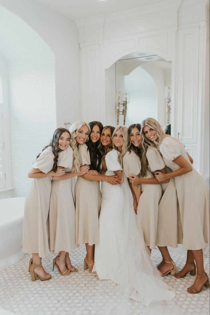 the bride and her bridesmaids are posing for a photo in their wedding dress