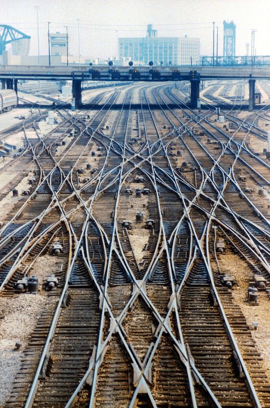 the train tracks are all parallel to each other in front of an overpass and bridge