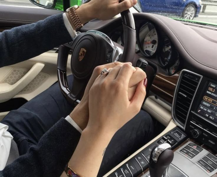 a woman driving a car with her hands on the steering wheel