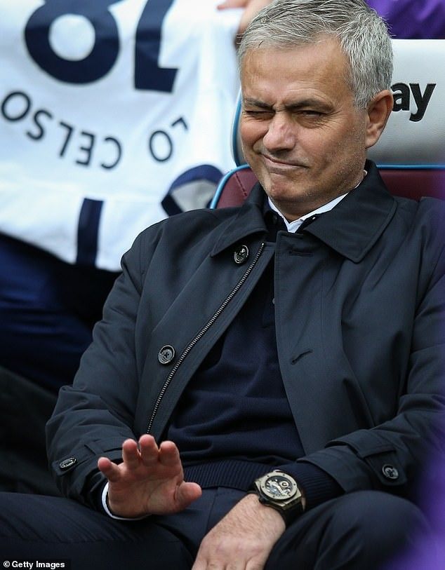 an older man sitting in a chair at a soccer game with his hands out to the side