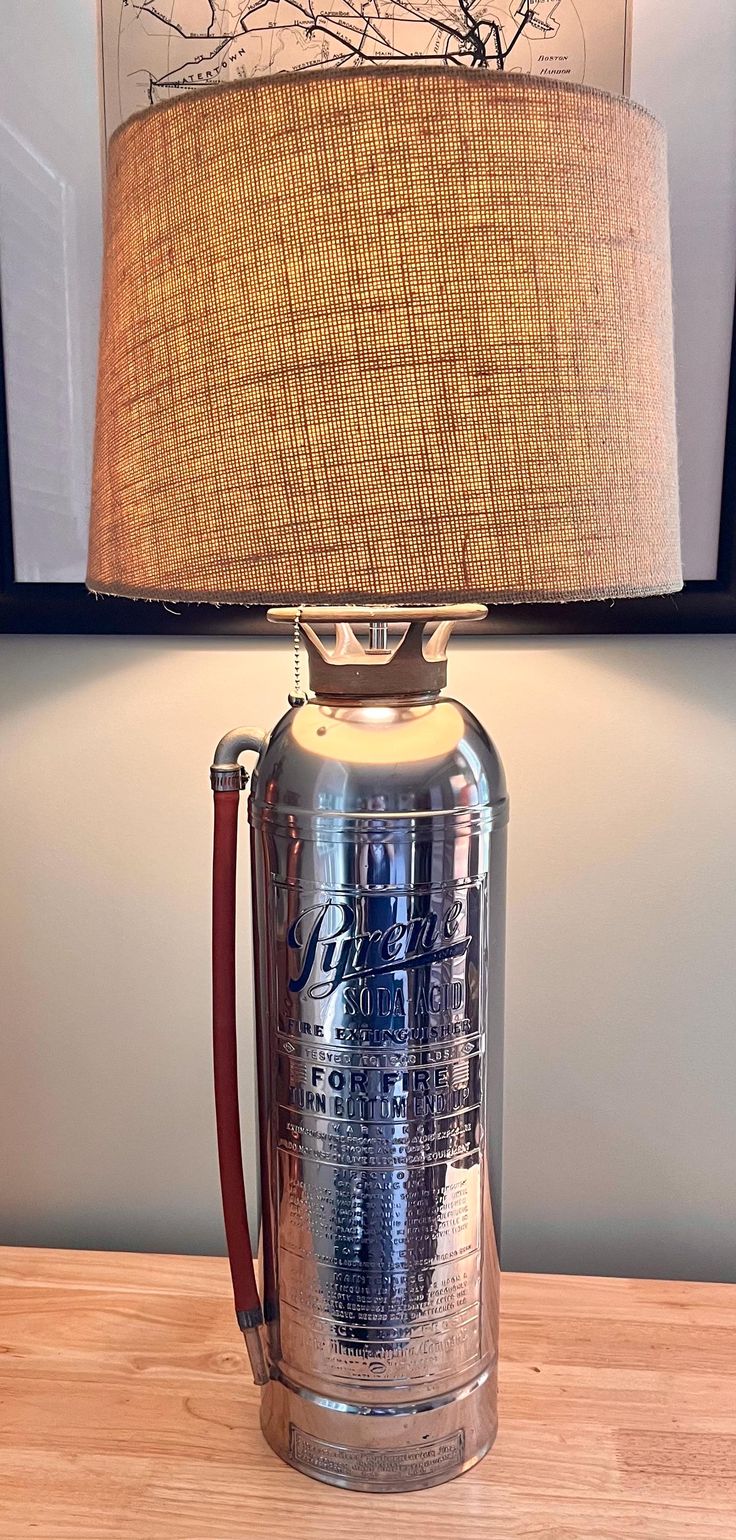 a lamp that is sitting on top of a wooden table next to a framed picture