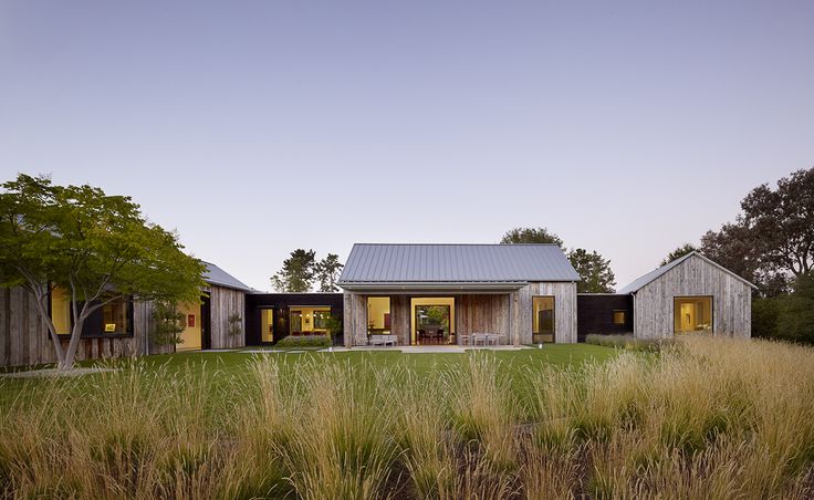 the house is surrounded by tall grass and trees