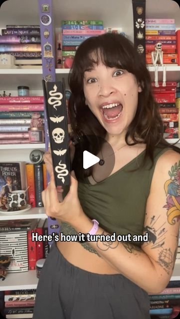 a woman holding up a large pair of skis in front of bookshelves