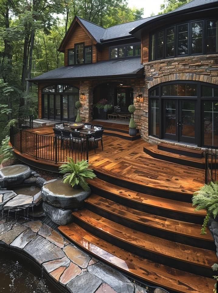 a large wooden deck in front of a house with steps leading up to the patio