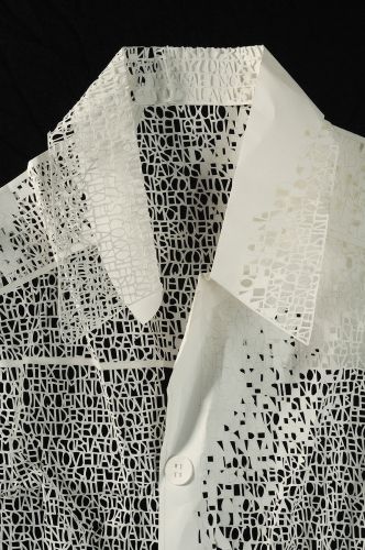 a white shirt with black and white designs on the front, made out of paper