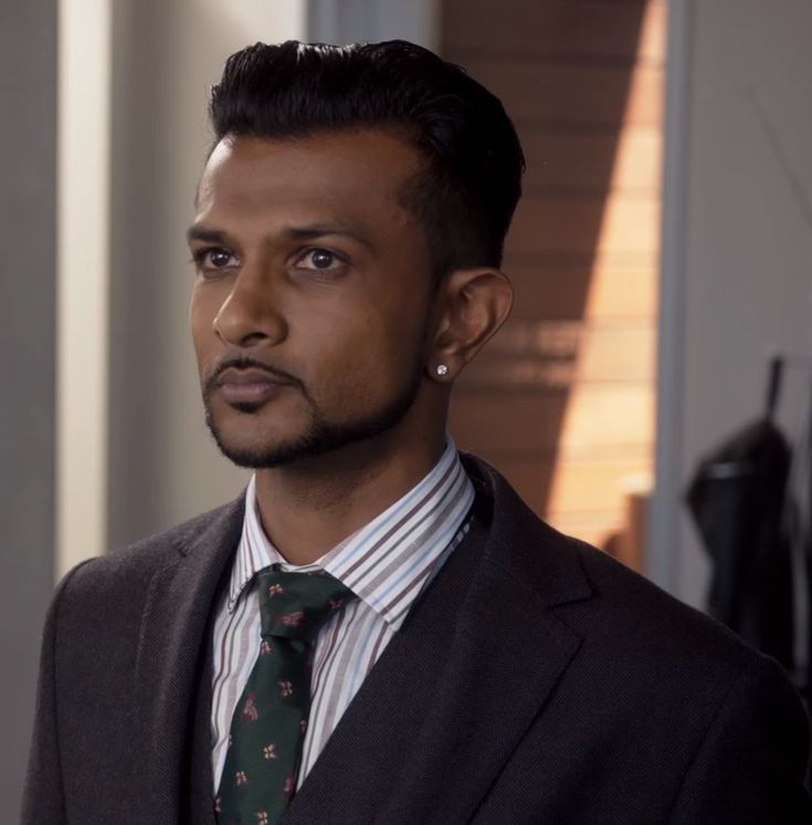 a man in a suit and tie looking at the camera