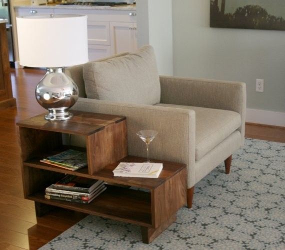 a living room filled with furniture and a lamp on top of a coffee table next to a book shelf