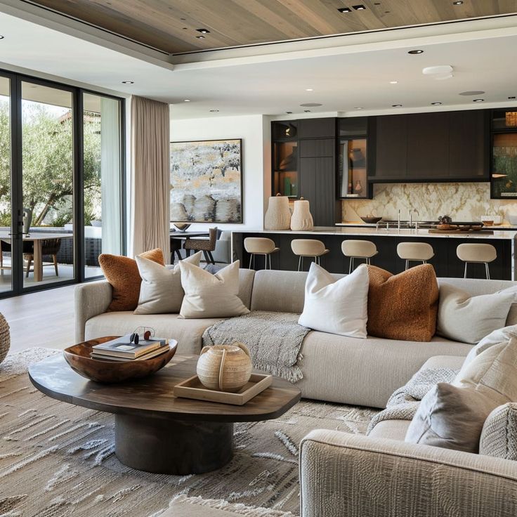 a living room filled with furniture next to a kitchen and an open concept dining area