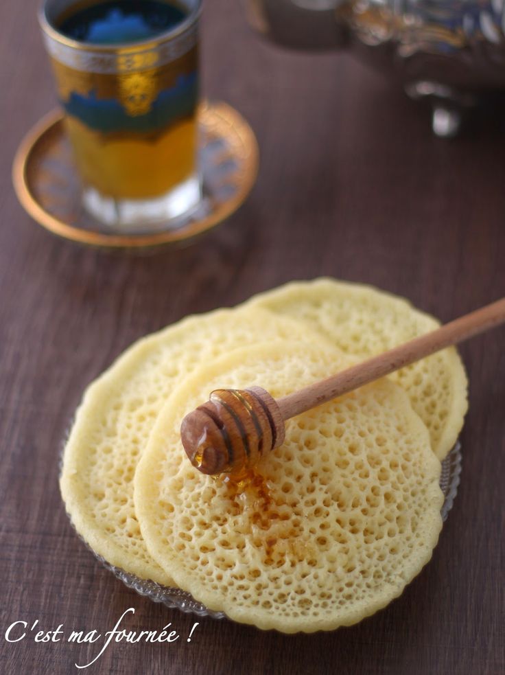 a wooden spoon sitting on top of a piece of bread next to a cup of tea