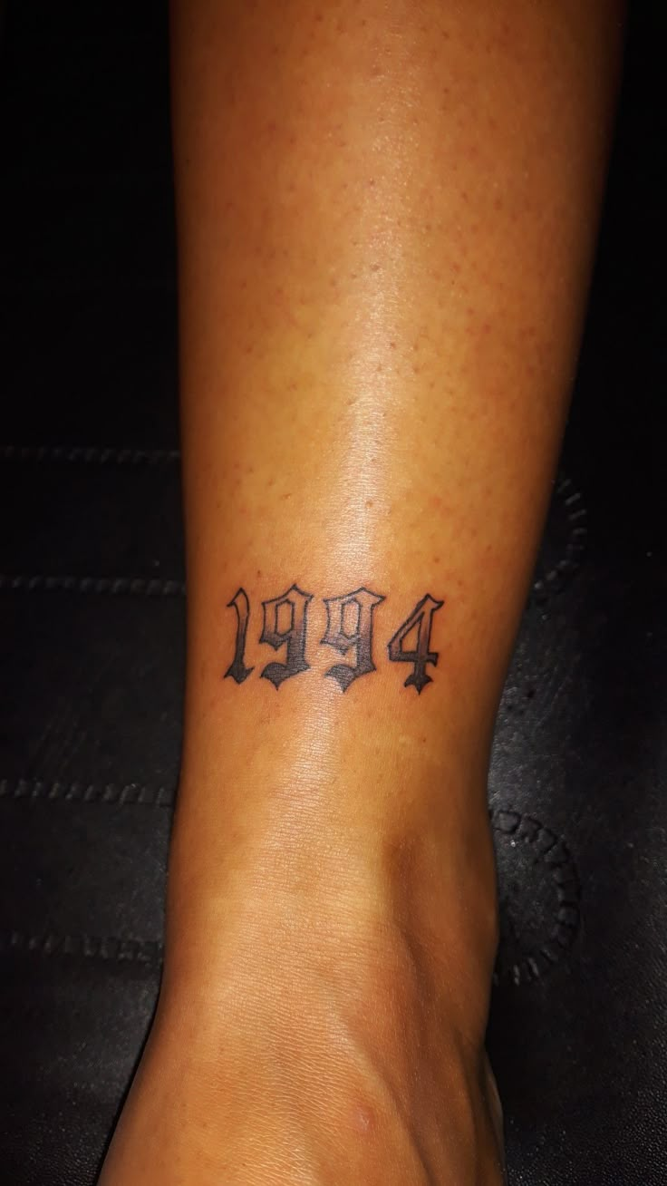 a woman's foot with the number four tattooed on her left side, and an arrow in the middle