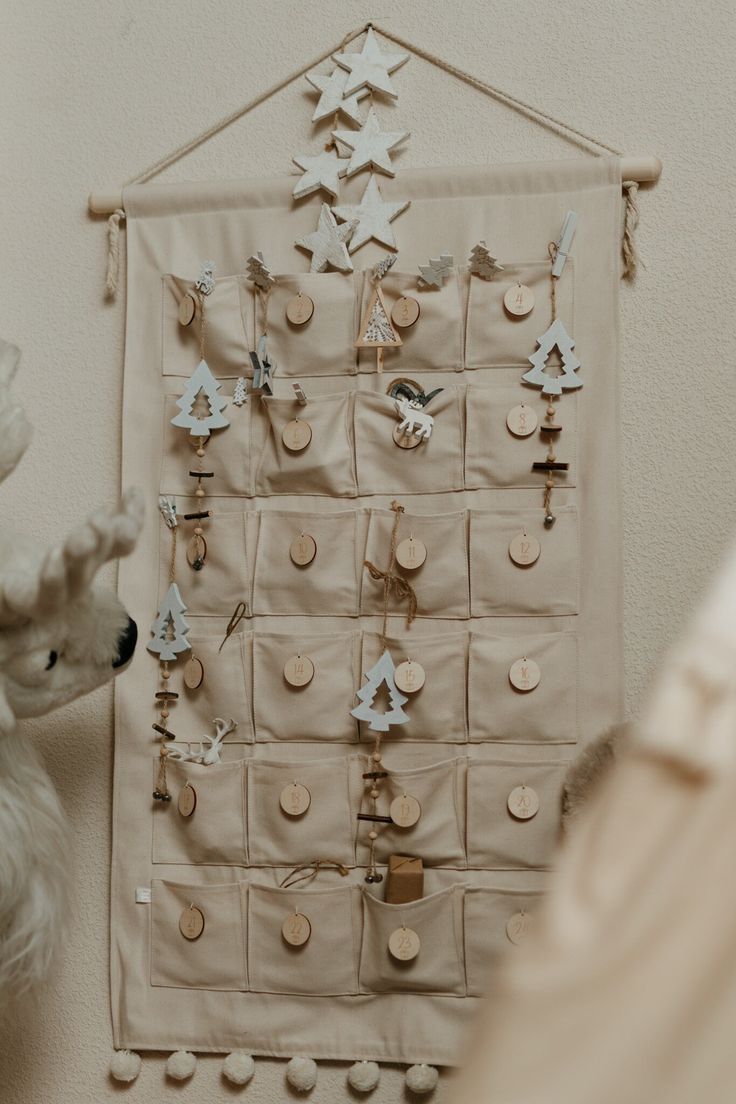 a white teddy bear sitting next to a wall hanging with buttons and stars on it