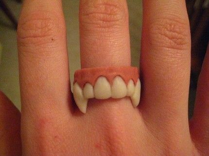 a person's hand with a fake tooth ring on it