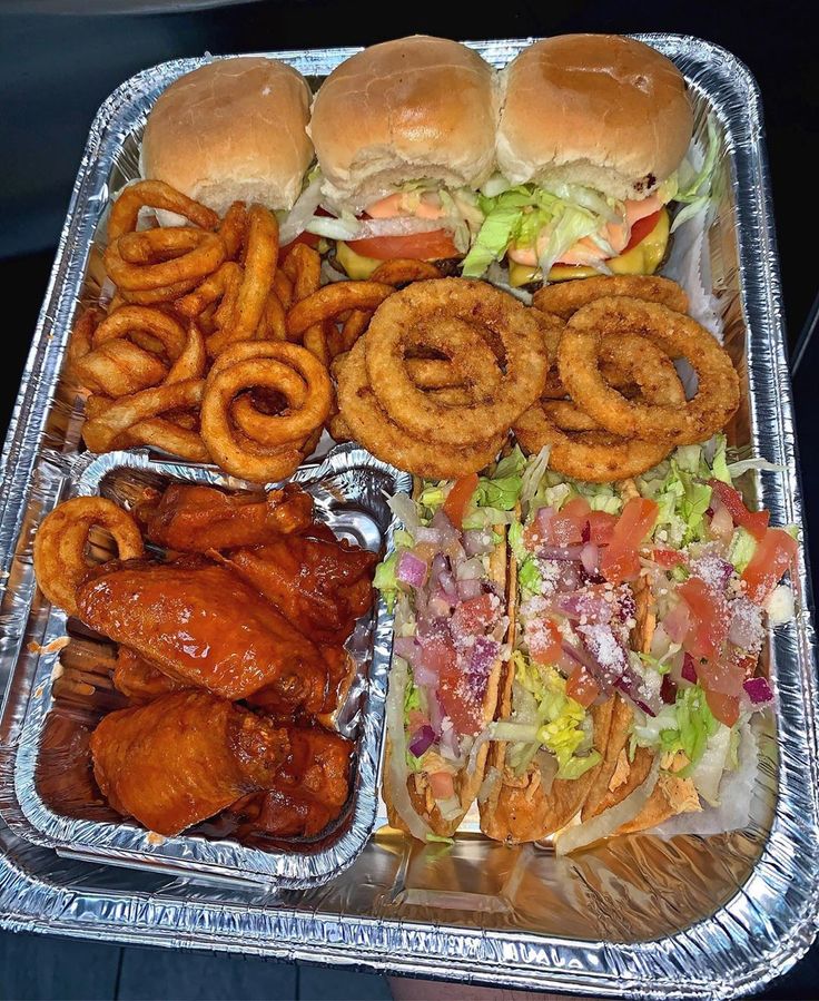 a tray filled with chicken wings, onion rings and cheeseburgers