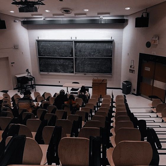 an empty classroom with chairs and a blackboard