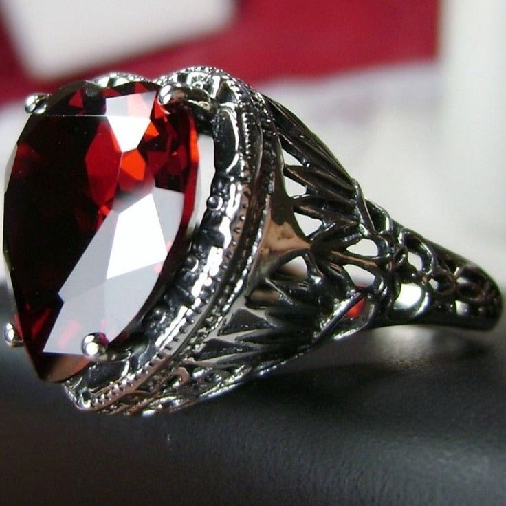 Red Heart Gem Sterling Silver RingHeart Vic Design#D59 The amazing Heart Vic is a romantic statement piece that will surely become a cherished heirloom. Perfect for those who love and admire antique jewelry with classic designs, this exquisite Victorian inspired ring is fashioned with a 10ct flawless red garnet Cubic Zirconia (CZ) center stone set within a beautiful gothic filigree setting. The stunning heart gem measures 15mmx15mmm and is raised 11mm off the finger for maximum sparkle and brill Elegant Filigree Jewelry For Valentine's Day, Heirloom Style Valentine's Day Jewelry Ring, Valentine's Day Heirloom Ring Jewelry, Valentine's Day Heirloom Ring, Heirloom Oval Jewelry For Valentine's Day, Classic Red Cubic Zirconia Jewelry, Antique Heart Cut Jewelry For Formal Occasions, Pear-shaped Jewelry For Valentine's Day Anniversary, Elegant Red Cubic Zirconia Rings