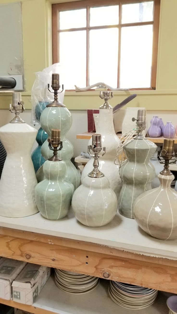 many vases and bowls are on a table