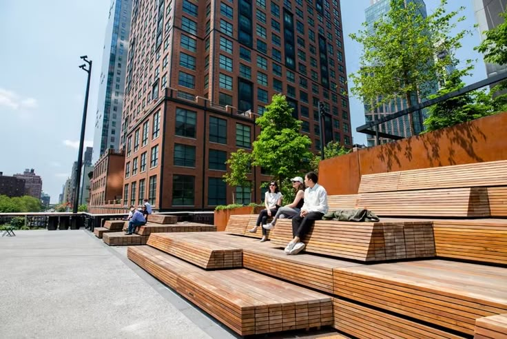 two men sitting on wooden benches in front of tall buildings