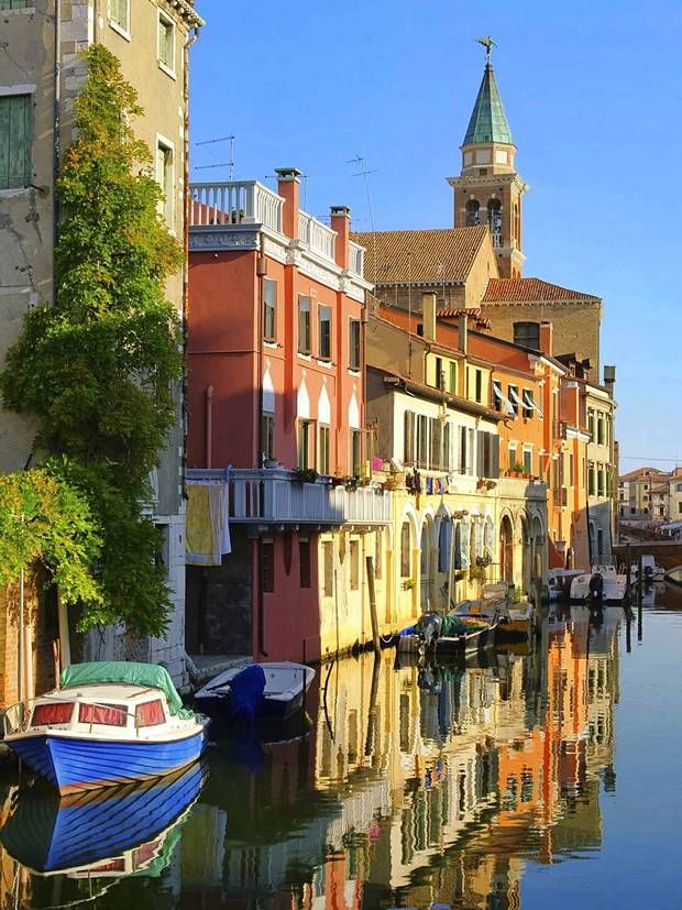 several boats are docked in the water next to buildings