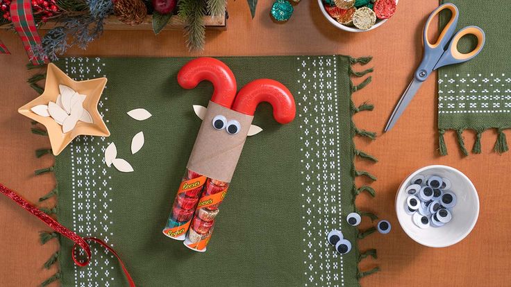 a table topped with lots of crafting supplies on top of a wooden table covered in christmas decorations