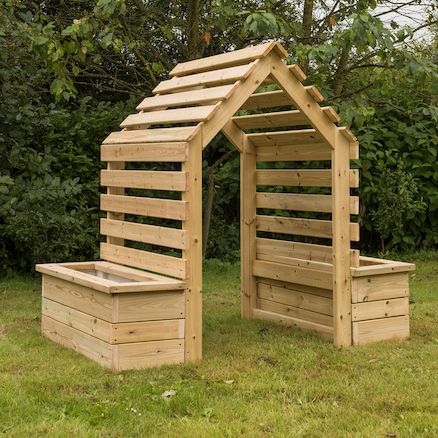 a wooden structure made out of pallets in the grass