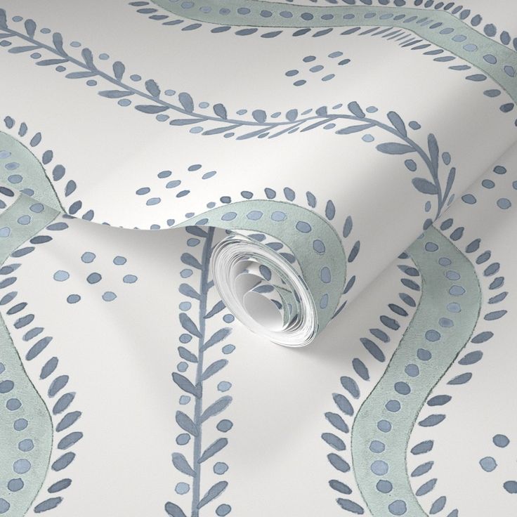 a wallpaper with blue and green leaves on it's side, next to a roll of white paper