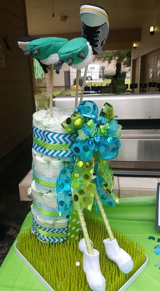 a diaper cake that is sitting on top of a table with green and blue decorations