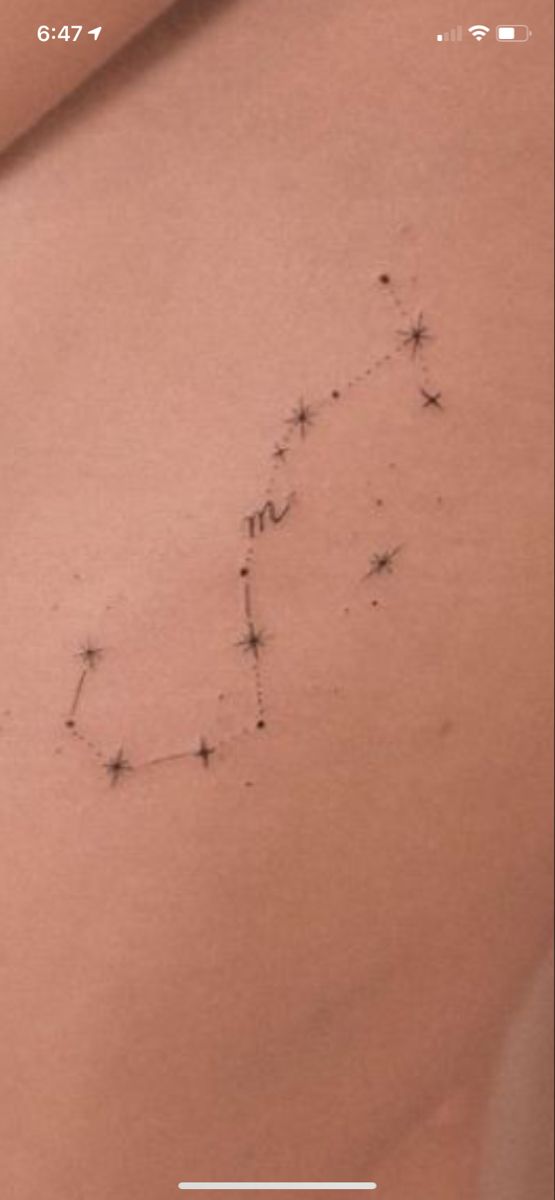 the back of a woman's stomach with small stars on her left side and an arrow in the middle