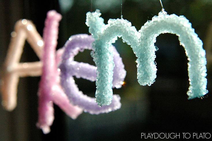 the letters are made out of soap bubbles and hung from strings in front of a window