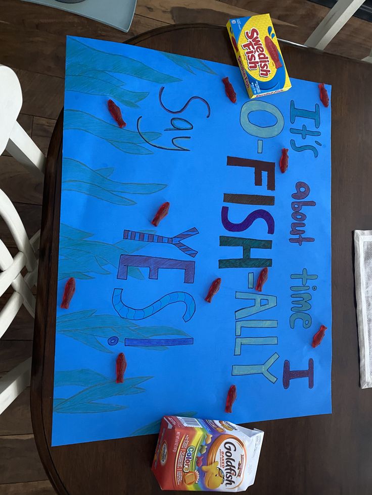 a blue sign sitting on top of a wooden table next to two rolls of candy