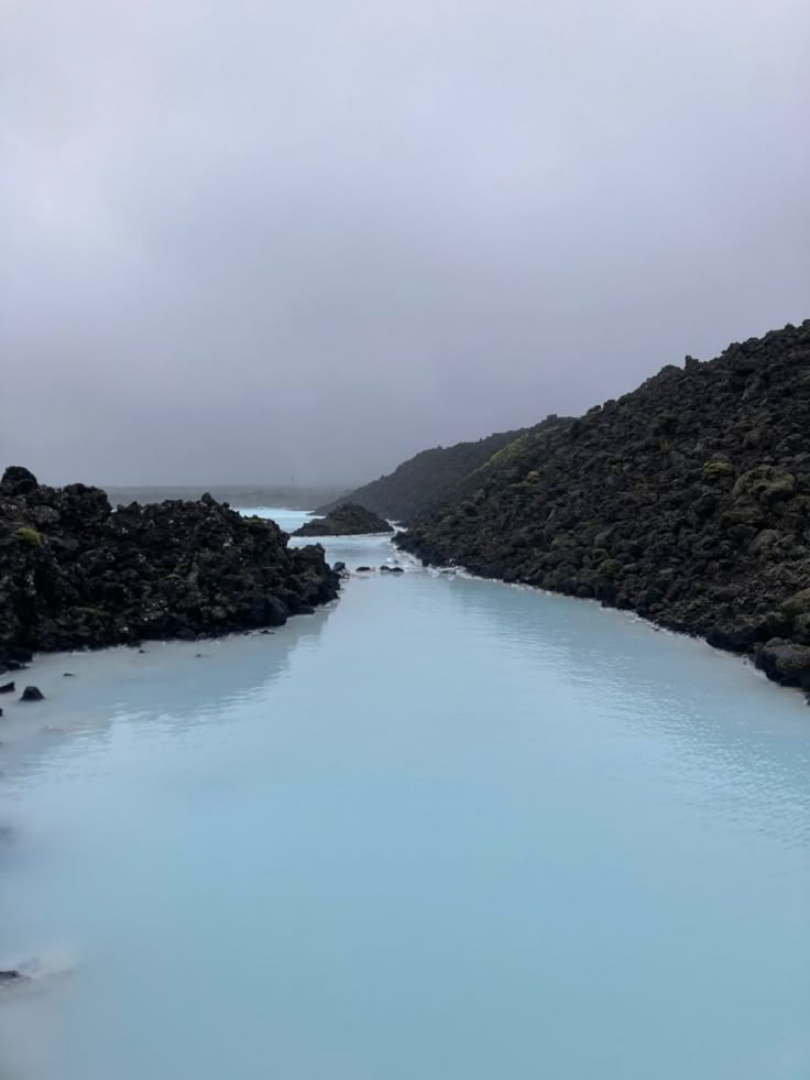 the blue lagoon is surrounded by rocky hills