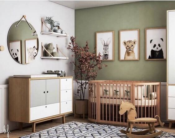 a baby's room with green walls and pictures on the wall, including a crib