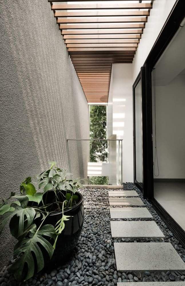 a modern house with a large planter in the entryway and stone flooring