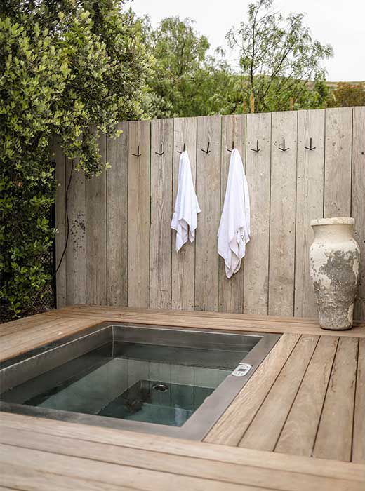 an outdoor hot tub with towels hanging on the wall