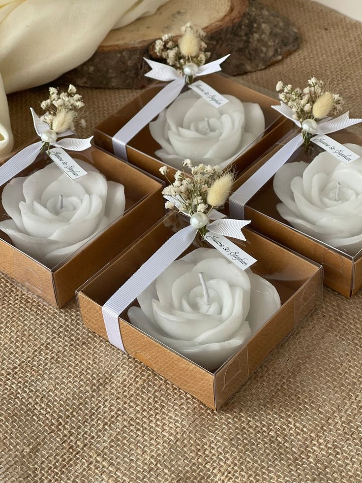 four small boxes with white flowers in them