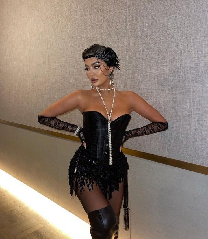 a woman in a black corset posing for the camera