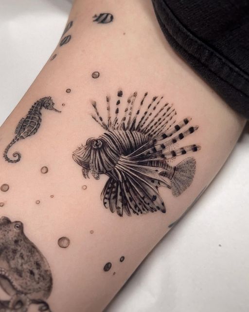 a black and white photo of a lionfish, seahorse, and octopus tattoo