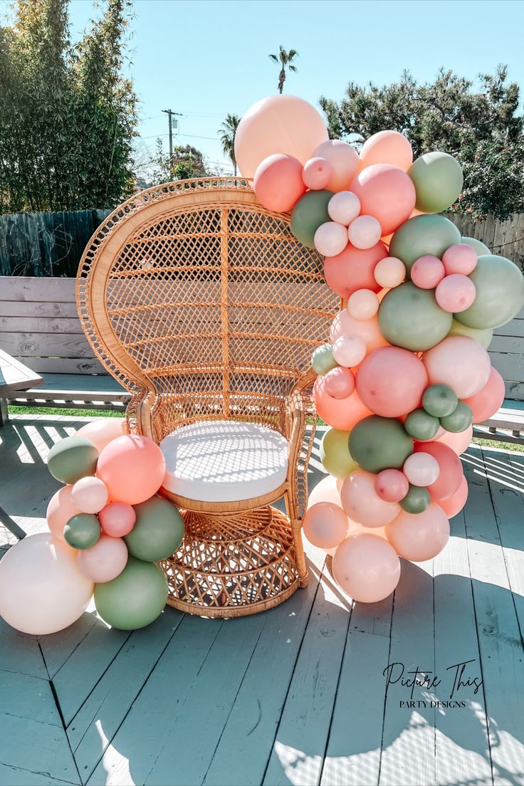 a wicker chair sitting on top of a wooden floor with balloons attached to it